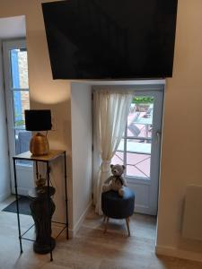 a teddy bear sitting in a chair in front of a door at La Terrasse Salon de The in Montmorillon +7 photos