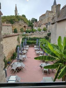 a group of chairs and umbrellas on a patio at La Terrasse Salon de The in Montmorillon