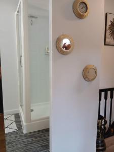 a shower stall in a bathroom with two pictures on the wall at La Terrasse Salon de The in Montmorillon