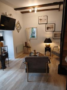 a living room with a couch and a tv at La Terrasse Salon de The in Montmorillon