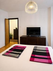 a bedroom with a white bed with pink and black mats at Apartment CenterZeroZone in Banja Luka