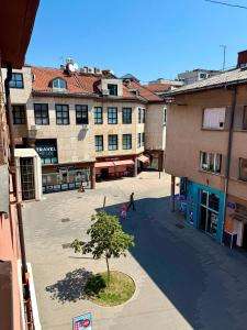 a group of buildings with a tree in a courtyard at Apartment CenterZeroZone in Banja Luka