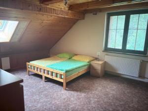 a small bedroom with a bed in a attic at Chalupa Pavlonka in Staré Hamry