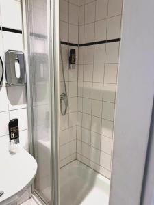 a bathroom with a shower with a toilet and a sink at Hotel Alameda in Hamburg