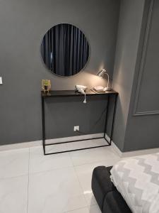 a bedroom with a bed and a mirror on the wall at Zameen Opal Executive 2-Bed Suite in Lahore