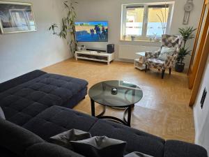 a living room with a couch and a table and a tv at Ferienwohnung Andalucia in Selb