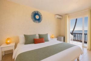 a bedroom with a bed with a view of the ocean at Lankraz Hotel Mauritius in Port Louis +25 photos