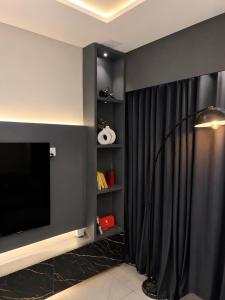 a living room with a black curtain and a television at Zameen Opal Executive 2-Bed Suite in Lahore