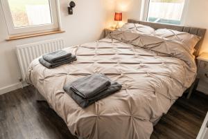 a bed with two towels on it in a bedroom at Cushendall Coastal Accommodation, Glens of Antrim - Beach & Mountain Access in Cushendall
