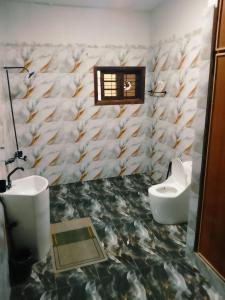 a bathroom with two toilets and a fish patterned wall at Beach Heaven Guest House in Karachi +16 photos