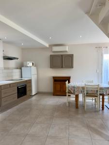 a kitchen with a table and a kitchen with a counter at Maison classée 3 étoiles avec garage et 2 terrasses in Arles-sur-Tech