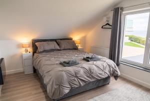 a bedroom with a bed and a large window at Cushendall Coastal Accommodation, Glens of Antrim - Beach & Mountain Access in Cushendall