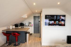 a kitchen with a counter and red stools at Cushendall Coastal Accommodation, Glens of Antrim - Beach & Mountain Access in Cushendall