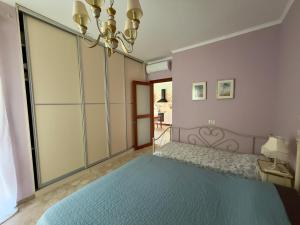 a bedroom with a blue bed and a chandelier at GH Mountain & Bay View with POOL in Gornji Orahovac +30 photos