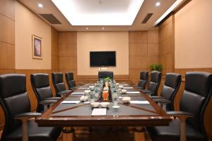 a conference room with a long table and chairs at Savoy Suites Greater Noida in Greater Noida