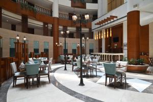 a restaurant with tables and chairs in a building at Savoy Suites Greater Noida in Greater Noida