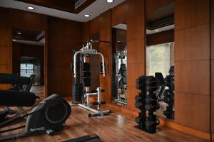 a gym with tread machines and mirrors in a room at Savoy Suites Greater Noida in Greater Noida
