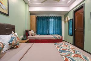 a small room with two beds and a window at FabHotel Maple Leaf in Hyderabad