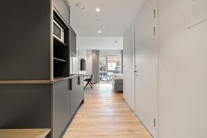 a hallway with white cabinets and a living room at Skudeløken Apartment Hotel in Førde