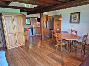 a kitchen and dining room with a wooden table and chairs at Vineyard Cottage - Ana in Metlika