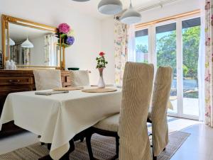 a dining room with a table and chairs and a mirror at VILLA climatisée - 4 étoiles - 75 m2 avec Jardin pour 3 personnes - à 10 min de Besançon in Dannemarie-sur-Crête