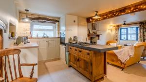 a kitchen with a counter and a stove top oven at Cotswold Way Cottage in Stroud