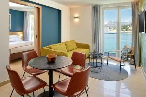 a living room with a couch and a table and chairs at Maistra Select Mlini Villas and Apartments in Mlini