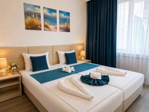 a bedroom with a large bed with towels on it at Guest House Kolev - central in Nesebar