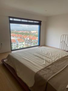 a large bed in a room with a large window at Sunora Stay A6 in Quang Ãm