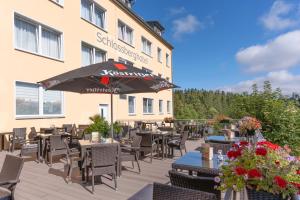a restaurant with tables and chairs and an umbrella at Schlossberghotel Oberhof in Oberhof