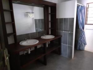 a bathroom with two sinks and a large mirror at Villa Armor 2 in Nosy Be
