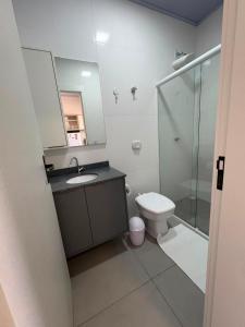 a bathroom with a toilet and a sink and a mirror at Estúdio J&C 05 A in Primavera do Leste