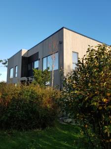 a building with glass windows on the side of it at Dugneberg in Karmøy