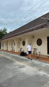 a woman is standing outside of a building at บ้านศรีสุธรรม3 Baansrisutham 3 in Don Sak +2 photos