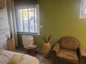 a room with a chair and a table and a window at Baune in La Bazoge