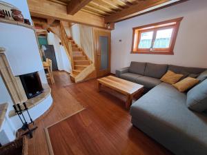 a living room with a couch and a tv and a table at Drevenica pod Lánom in Zuberec
