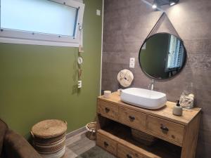 a bathroom with a sink and a mirror on a dresser at Baune in La Bazoge