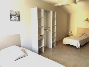 a bedroom with two beds and a closet with shelves at Maison classée 3 étoiles avec garage et 2 terrasses in Arles-sur-Tech