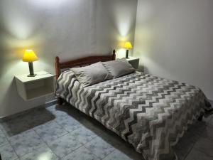a bedroom with a bed and two lamps on night stands at Postal del Golfo in Las Grutas