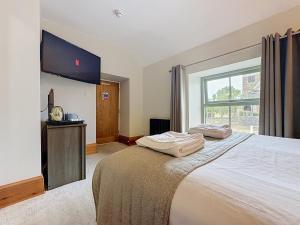 a bedroom with a large bed and a large window at George and Dragon in Holmesfield