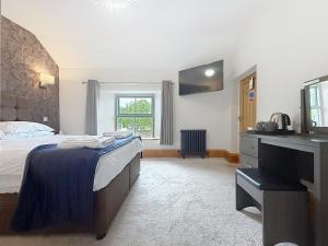 a bedroom with a bed and a desk and a sink at George and Dragon in Holmesfield