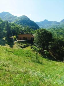 a house in the middle of a field with mountains at Gîte au calme 