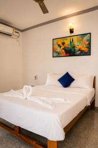 a bedroom with a large bed with white sheets at Casa de Arambol in Arambol