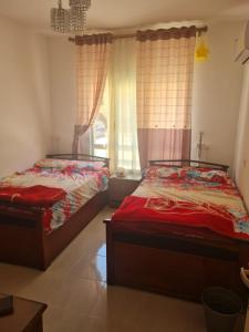 a bedroom with two beds and a window at شاليه بلومار السخنة in Ain Sokhna