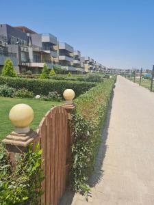 a wooden fence next to a sidewalk next to a building at شاليه بلومار السخنة in Ain Sokhna