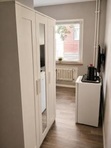 a white cabinet with a mirror in a room at Laroni in Duisburg