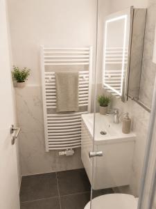 a white bathroom with a toilet and a sink at Laroni in Duisburg