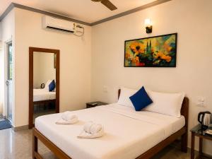 a bedroom with two beds and a painting on the wall at Casa de Arambol in Arambol