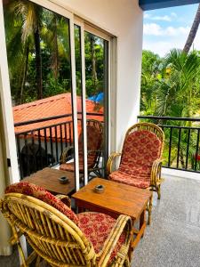 a porch with chairs and a wooden table and a table at Casa de Arambol in Arambol +32 photos