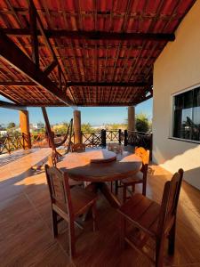 a dining room with a table and chairs on a deck at Casa du Vento in Cruz